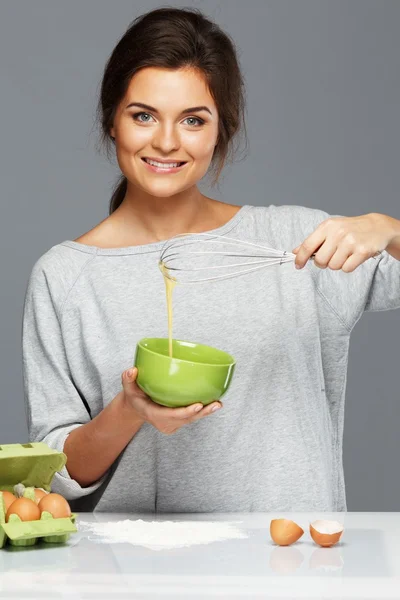 Jonge vrouw eieren voor een deeg te zwaaien — Stockfoto