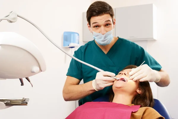 Νεαρή γυναίκα και άντρας γιατρός σε χειρουργική επέμβαση του οδοντιάτρου — Φωτογραφία Αρχείου