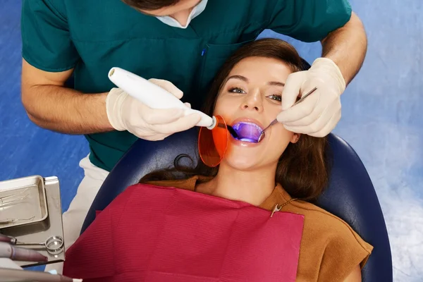 Mujer joven y hombre médico en la cirugía del dentista —  Fotos de Stock