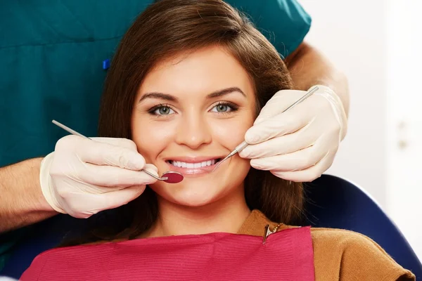 Jeune femme brune à la chirurgie du dentiste gros plan — Photo