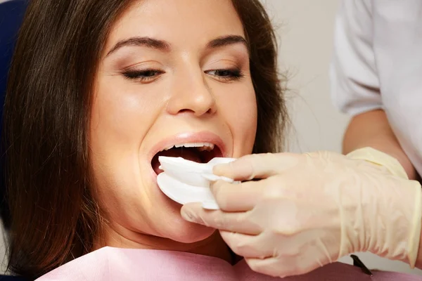 Dentista haciendo procedimiento de blanqueamiento de dientes a paciente mujer —  Fotos de Stock