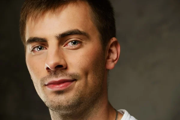 Handsome young man in white t-shirt on grunge background — Stock Photo, Image