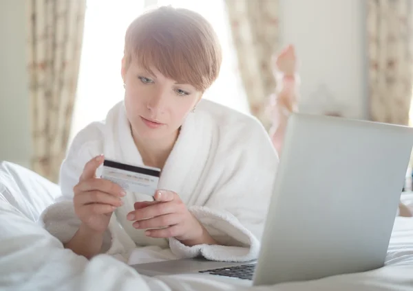 Femme en peignoir payant en ligne avec une carte de crédit — Photo