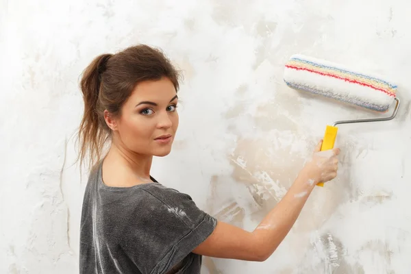 Beautiful young brunette woman doing wall painting — Stock Photo, Image