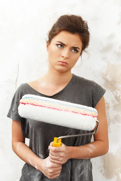 Ontevreden jonge brunette vrouw doen wandschildering — Stockfoto