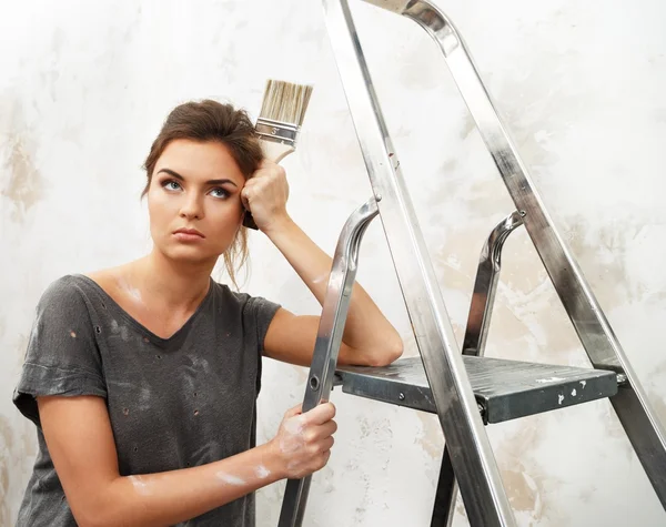 Missnöjda ung brunett kvinna med stege och målning borste — Stockfoto