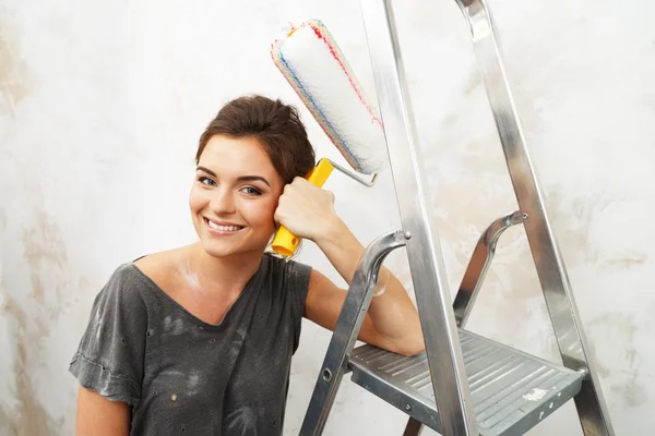 Feliz bela jovem fazendo pintura de parede — Fotografia de Stock