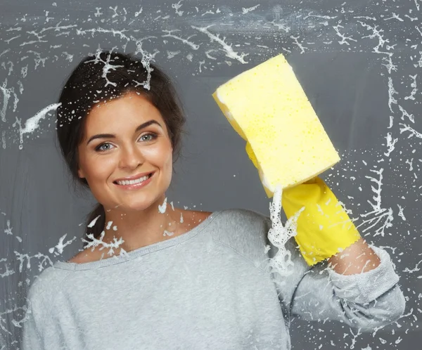 Young beautiful brunette woman cleaning window glass — Stock Photo, Image