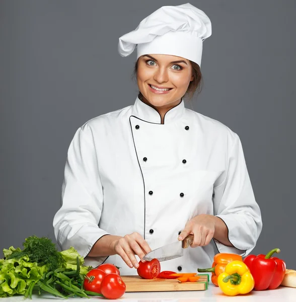 Divertida loca joven cocinera cortando tomates frescos — Foto de Stock