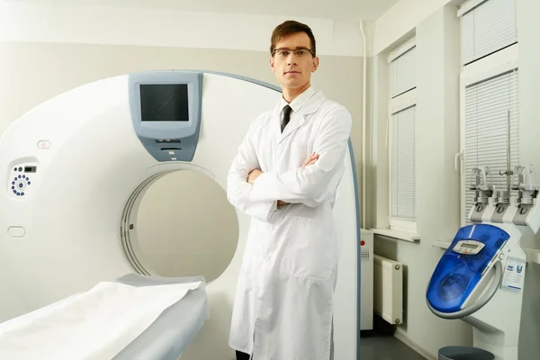 Jonge dokter permanent in de buurt van computertomografie scanner in een ziekenhuis — Stockfoto