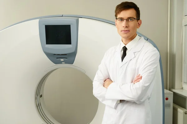 Jonge dokter permanent in de buurt van computertomografie scanner in een ziekenhuis — Stockfoto