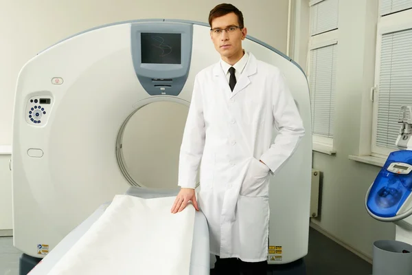 Jonge dokter permanent in de buurt van computertomografie scanner in een ziekenhuis — Stockfoto
