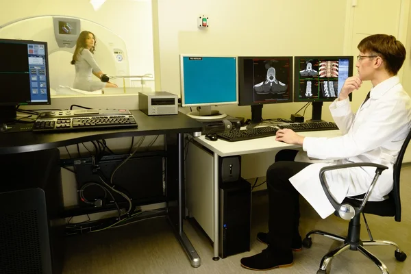 Jovem médico sentado atrás de monitores em um laboratório de tomografia computadorizada — Fotografia de Stock