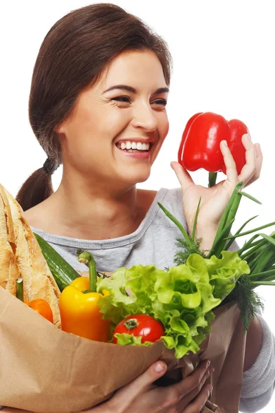 Mujer morena sonriente con bolsa llena de verduras frescas y pimentón rojo — Foto de Stock