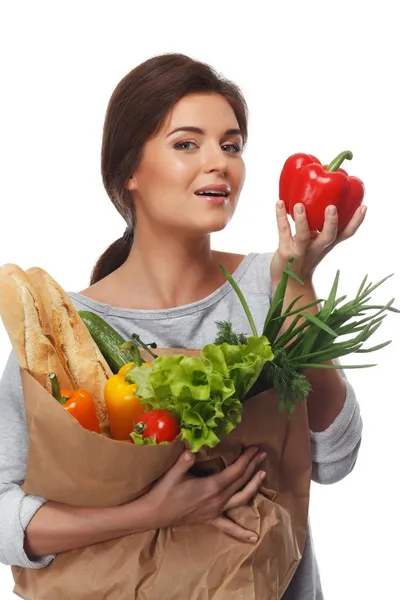 Mulher morena sorridente com saco de supermercado cheio de legumes frescos e páprica vermelha — Fotografia de Stock
