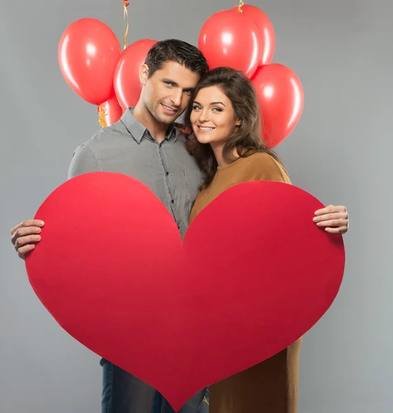 Lyckliga par handgjorda papper hjärta och röda ballonger — Stockfoto
