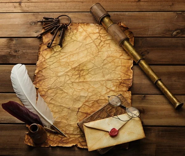 Old keys, spyglass and writing accessories on old blank paper over wooden background — Stock Photo, Image