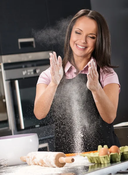 Mladá žena se baví s moukou přitom těsto na moderní kuchyň — Stock fotografie