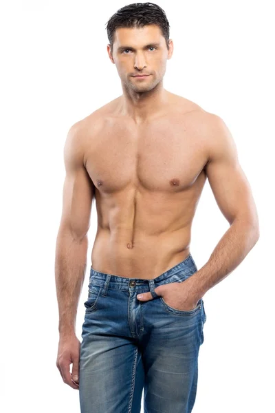 Красивый молодой человек в синих джинсах с голым туловищем — стоковое фото