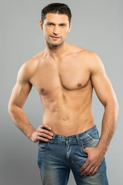 Schöner junger Mann in blauen Jeans mit nacktem Oberkörper — Stockfoto