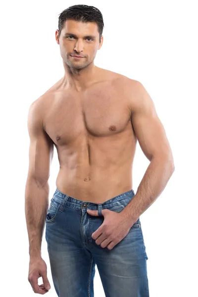 Красивый молодой человек в синих джинсах с голым туловищем — стоковое фото