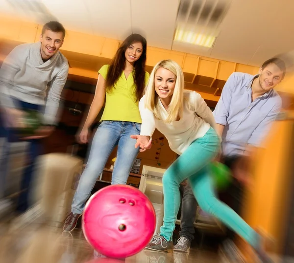 Grupo de quatro jovens sorrindo jogando boliche — Fotografia de Stock