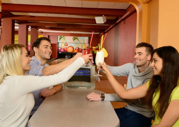 Grupo de quatro jovens sorrindo pessoas conversando atrás da mesa no clube de bowling — Fotografia de Stock