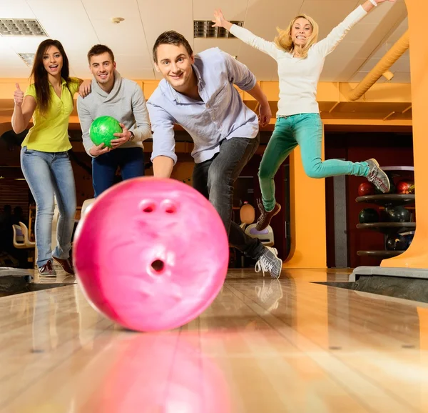 Grupo de cuatro jóvenes sonriendo jugando a los bolos —  Fotos de Stock