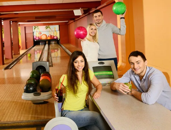 Vier Jugendliche im Kegelclub mit Bällen und Getränken — Stockfoto