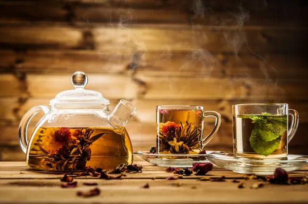 Tetera y tazas de vidrio con té sobre fondo de madera —  Fotos de Stock