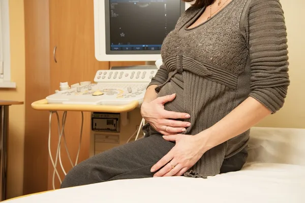 Young pregnant woman in ultrasound examination cabinet at hospital — Stock Photo, Image
