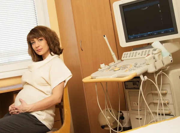 Young pregnant woman in ultrasound examination cabinet at hospital Stock Picture