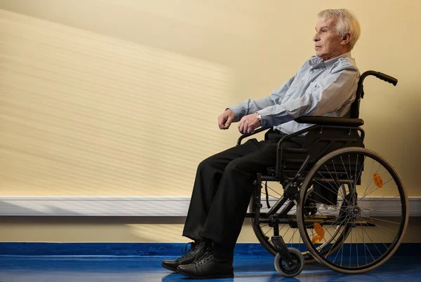Продуманий старший чоловік в інвалідному візку в будинку престарілих — стокове фото