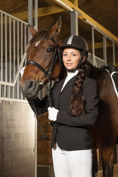Красивая девушка с лошадью в стойле — стоковое фото