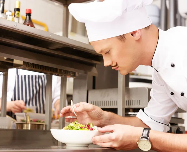 Jonge chef-kok met gastronomische gerechten op keuken in restaurant — Stockfoto