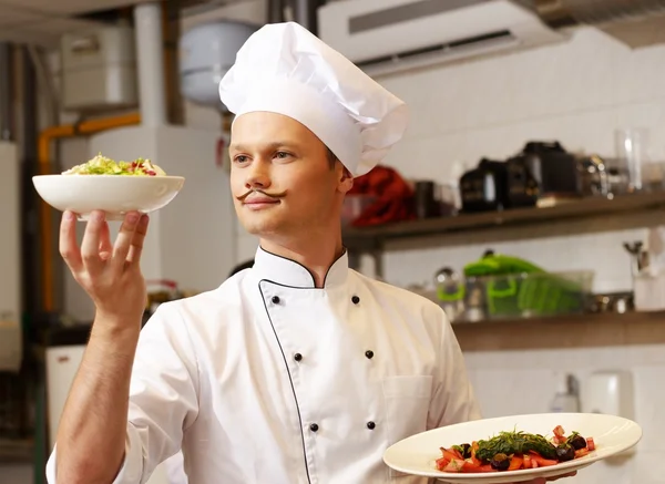 Jeune chef cuisinier avec de la nourriture gastronomique sur la cuisine dans le restaurant — Photo