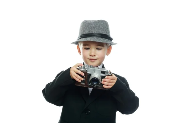 Kleiner Junge mit Hut und schwarzem Anzug mit Vintage-Kamera auf weißem Hintergrund — Stockfoto