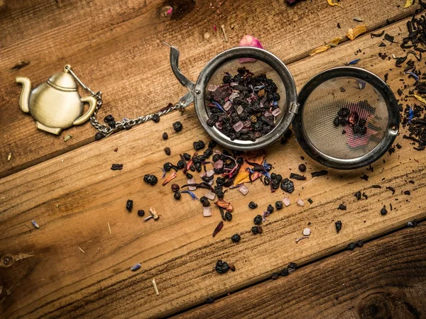 Te stainers med aromatiska te på träbord bakgrund — Stockfoto
