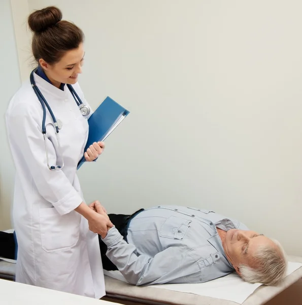 Homme âgé allongé au lit de repos dans le bureau du médecin — Photo