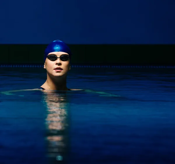 Giovane donna in berretto blu e costume da bagno in piscina — Foto Stock