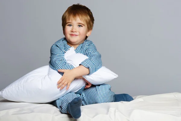 身穿蓝色睡衣在床上的小男孩 — 图库照片