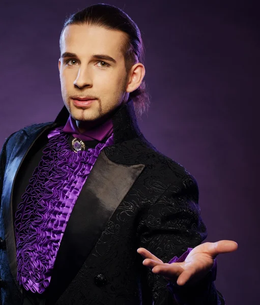 Young handsome brunette magician in stage costume — Stock Photo, Image