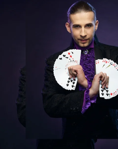 Joven mago morena en traje de escenario mostrando trucos de cartas — Foto de Stock
