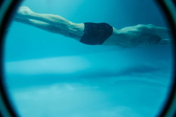 Uomo in cuffia e googles sott'acqua in piscina — Foto Stock