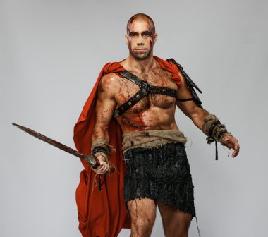 Wounded gladiator with sword covered in blood isolated on grey clipart