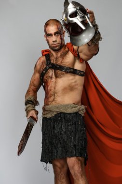 Wounded gladiator with sword covered in blood and helmet isolated on grey clipart