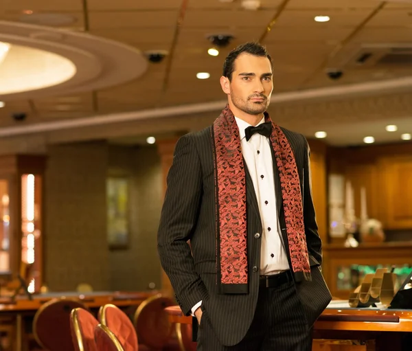 Handsome brunette wearing suit and scarf in luxury interior — Stock Photo, Image