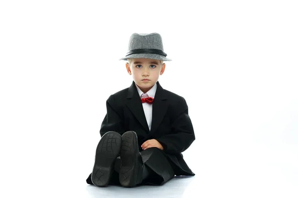 Маленький мальчик в шляпе и черном костюме изолирован на белом фоне — стоковое фото