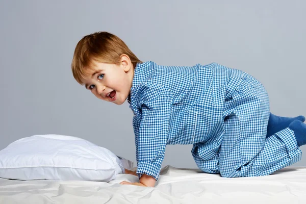 Menino vestindo pijama azul na cama — Fotografia de Stock