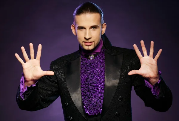 Young handsome brunette magician in stage costume — Stock Photo, Image